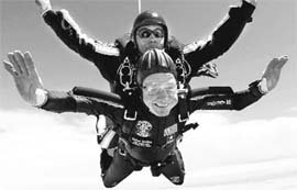 Former US President George HW Bush rides tandem with Sgt. Michael Elliott of the Armys Golden Knights parachute team to celebrate his 85th birthday on Friday.
