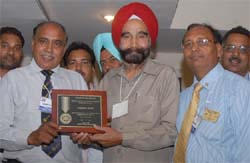 Rotarian Sukhdev Singh receiving the Service Above Self Award from the outgoing district governor, Ashwpat Rathore, in Bathinda 