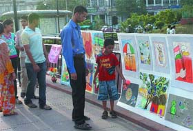 CHILDRENS WORLD: Visitors admire paintings made by children of government schools displayed in an exhibition organised by the NDMC at Central Park in New Delhi