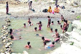 Children bathe in a pond at Santhla Devi Temple near Dehradun. 