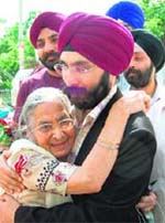 Captain Jasprit Chawla's mother Bhupinder Kaur hugs him on his arrival in Dehradun on Sunday. 