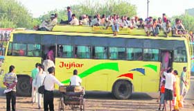 An overloaded bus carries labourers at Jagraon.