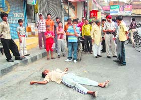 Callous residents, along with a policeman, look on as a man lies dead near Domoria bridge in Ludhiana