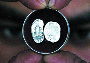 A picture of Guru Arjan Dev inscribed on a rajmah seed, is accompanied with a brief history inscribed on a piece of turmeric.