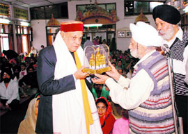 Ravail Singh, president of the Shri Guru Singh Sabha, presenting a memento to Chief Minister Prof Prem Kumar Dhumal on the occasion of martyrdom day of Guru Arjan Dev at a gurdwara in Shimla on Wednesday.