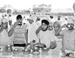 Sweetened water being distributed in the Golden Temple complex to mark the martyrdom day of Guru Arjan Dev on Tuesday.