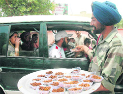 An Army jawan distributes “parshad” during a “chabeel” at N Area near airport in Chandigarh on Wednesday.
