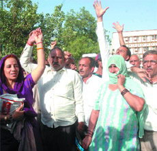 People duped by former MLA Ranvir Singh Kharb protest against him at Tis Hazari Courts in New Delhi on Thursday.