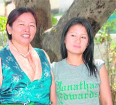 A young Tibetan girl in jeans while her mother prefers the traditional attire.
