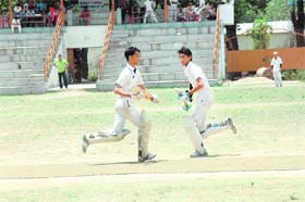 Batsmen playing for the Krishan Devi Garg Memorial Cricket Tournament in Dehradun cross over for a run