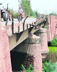 A bridge with a broken railing in Shekupura village on the Karnal-Meerut highway