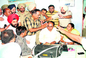 MC officials and shopkeepers argue at the police station in Chaura Bazar after a spat in Ludhiana on Thrusday.