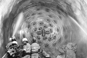 Miners stand in front as the drill machine Gaby breaks through the rock at the section Erstfeld-Amsteg at the construction site of the NEAT Gotthard Base Tunnel on June 16