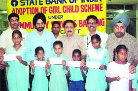 Daljit Singh, Regional Manager, SBI (second from left), distributes cheques among poor children in Amritsar