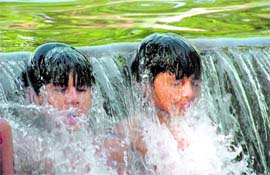 To beat the heat, youngsters take a dip in a canal at Lacchiwala near Dehradun.