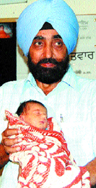 A doctor presents the baby, who was born through soft IVF technique, in Amritsar on Saturday.
