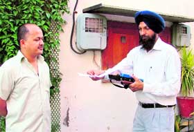 A PSEB employee prepares bill from a hand-held computer at the residence of a consumer after the introduction of spot billing in two more distribution divisions in Ludhiana.