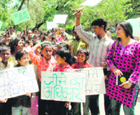 Slum children hold placards during a rally at Gandhi Park in Dehradun on Sunday.