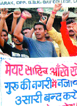 Protesters raise slogans against Mayor Shwet Malik in Amritsar on Sunday.