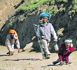 These physically challenged devotees traverse a rough terrain on their way to Amarnath shrine on Sunday.