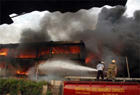Firefighters try to extinguish flames at an Adidas godown in Gurgaon