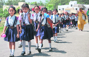 Students of Kendriya Vidyalaya, Hathibadkala, return home on the first day after the summer break in Dehradun on Monday.