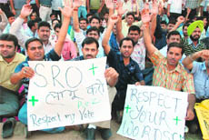 Members of the J&K Agricultural Technocrats Association protest in front of the Division Commissioners office in Jammu on Monday.
