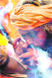 A sadhu enjoys a chillum after registering himself for the Amarnath Yatra in Jammu. 