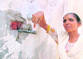 A woman shows the pipe without tap which was removed by the Gurdwara Committee 10 days ago