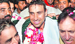Fans greet Pakistan's captain Younis Khan after his arrival in Karachi on Tuesday
