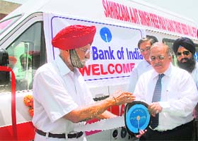 SBI CGM (Chandigarh circle) Ajay Swaroop hands over the keys to the ambulance to trust president Maj-Gen MS Kandal at Perch village, near Chandigarh