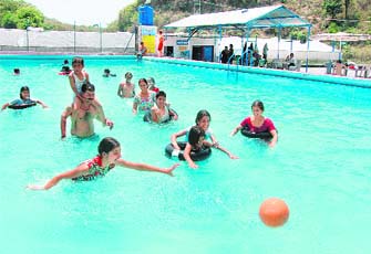 People have fun at a swimming pool in Guchu Pani in Dehradun