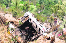 A cop guards the bus wreckage at Painthal.