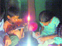 Children of Gidhpur village do their schoolwork in the light of a kerosene lamp. 