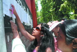 Admission seekers check out the first cut-off list at Hindu College in New Delhi on Thursday.