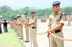 Police personnel wait for Chief Minister designate Ramesh Pokhriyal 'Nishank' at Sahastradhara helipad in Dehradun on Thursday.