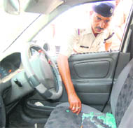 A policeman examines the car in which the couple was shot