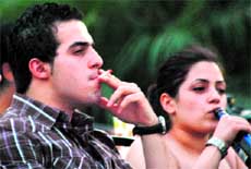 A youth smokes a cigarette in a club in Gurgaon.