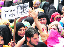 Demonstrators shout We Want Freedom slogans holding aloft a placard with pictures of the Shopian victims during a protest in Srinagar on Thursday.  