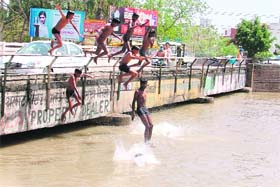 Slum youths take a dip in the Sidhwan canal to beat heat in Ludhiana