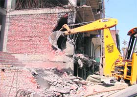 A JCB machine demolishes illegal structures in Ludhiana