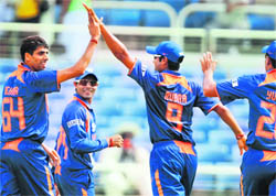 Ashish Nehra (L) celebrates with teammates after dismissing Chris Gayle on Saturday.