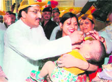 Chief Minister Ramesh Pokhriyal Nishank gives polio drops to a child in Dehradun on Sunday. 