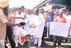 Activists of the Nirbhow Nirvair Organisation and parents burn an effigy of the Education Minister in Jammu on Sunday.