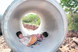 These children of manual labourers try to escape the scorching sun by taking shelter in a pipe in Jammu. 