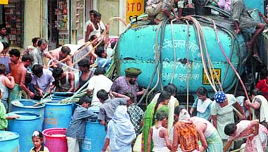 Residents jostle to fill water from a tanker at Najafgarh in New Delhi on Monday.