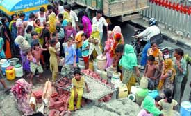 People queue up for water at Nand Nagri in the Trans-Yamuna area.