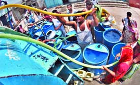 Residents take water in a south Delhi area.