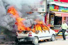 Smoke billows from a car that caught fire in a market in Gurgaon on Monday.