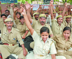 Members of the Prantiya Raksha Dal from Uttar Pradesh shout slogans in favour of their demand to make their jobs permanent, at Jantar Mantar in New Delhi on Tuesday.